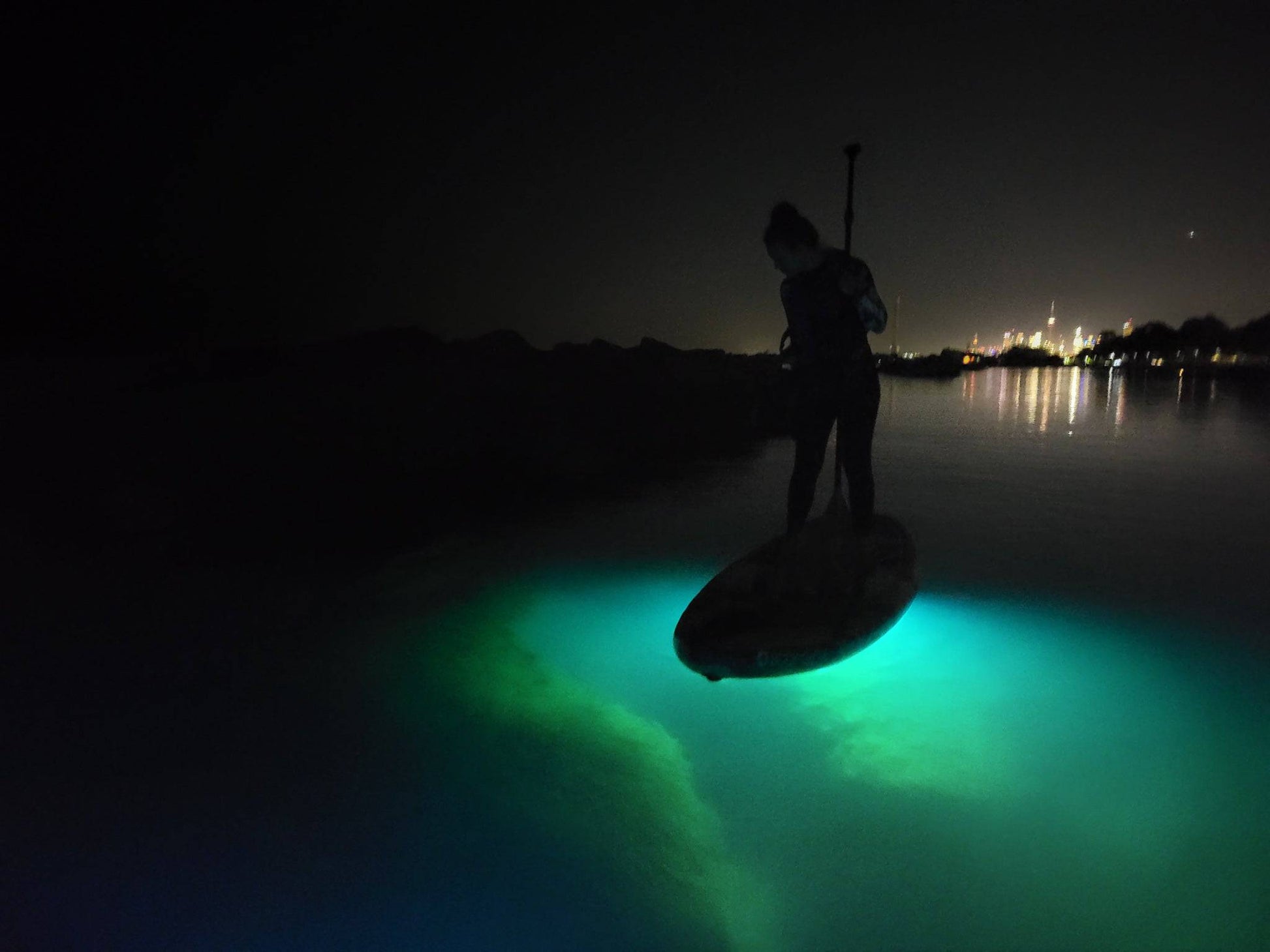 Aurora Explorer paddle board lights illuminate the rocks and aquatic life below the SUP.